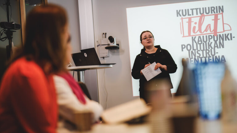 Henkilö pitää esitystä yleisön edessä.