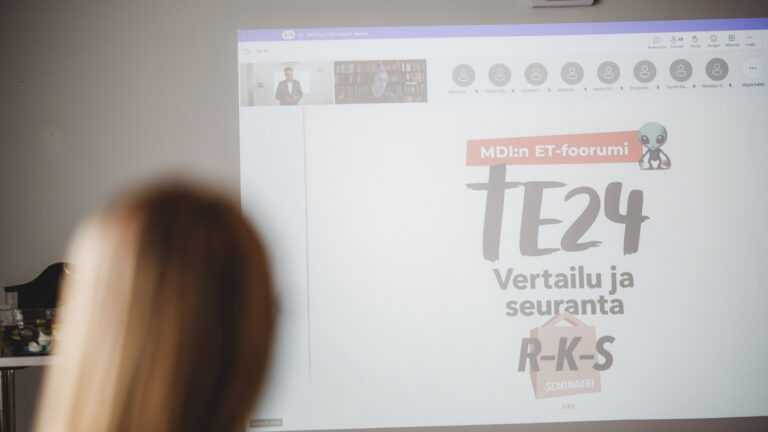 Kuva valkoisesta seinästä, jolle on heijastettu Teams-kokouksen näkymä.