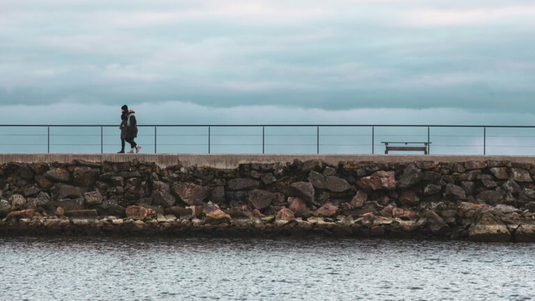 Kaksi kulkijaa veden äärellä. Kuva: Tapio Haaja / Unsplash.
